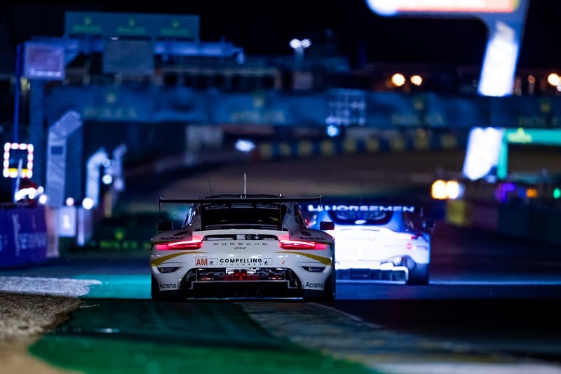 LM GTE Am Porsche on track at Circuit de la Sarthe during the night.